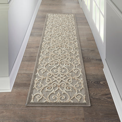 Long hallway runner rug with cream-beige scrolling damask on gray-taupe; bordered edges in a bright entryway.