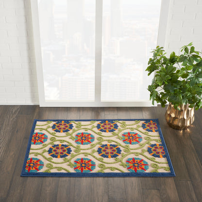 Colorful patterned rug (3' x 4') with blue border and floral medallions on a beige background, placed indoors near a window with a plant.