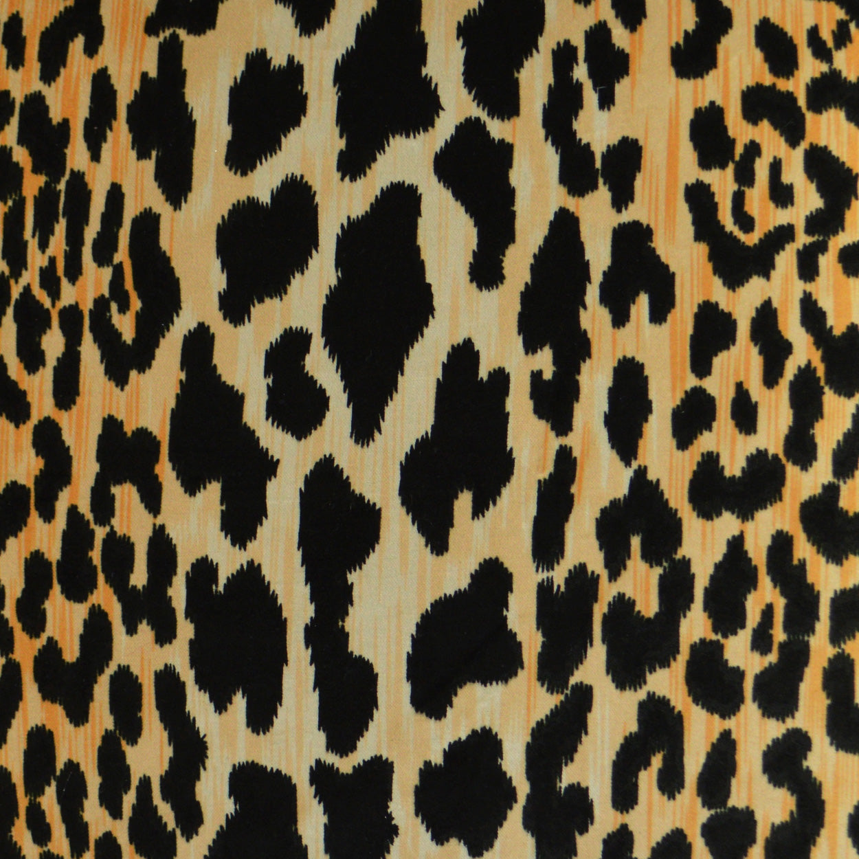 Leopard print pillow fabric with a warm tan background and bold black irregular spots.