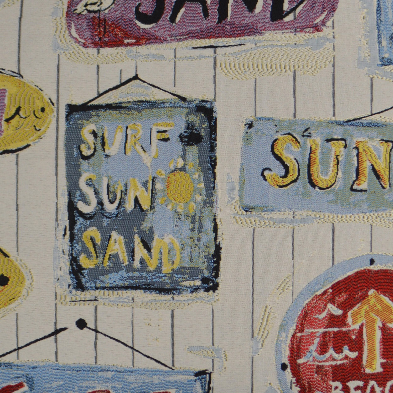 Fabric print with blue distressed sign reading SURF SUN SAND, plus yellow sun icons and beachy signs.