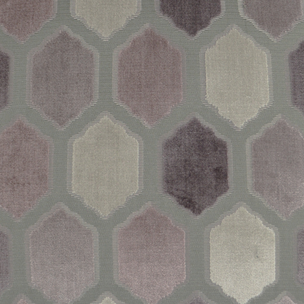 Velvet-like fabric with a hexagon lattice pattern in muted mauve, taupe and cream on sage backdrop.