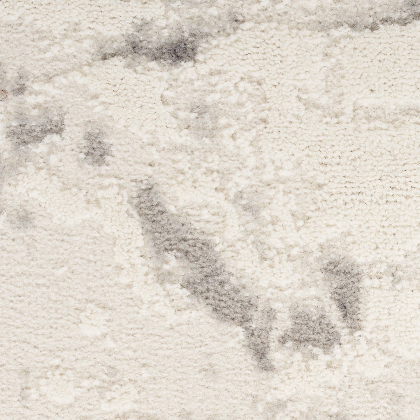 Cream plush rug with subtle gray marbling and soft, fuzzy texture for cozy living room decor.