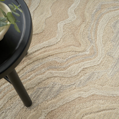 Beige abstract-pattern rug with wavy cream and tan lines, paired with a black round-side table and a green potted plant.