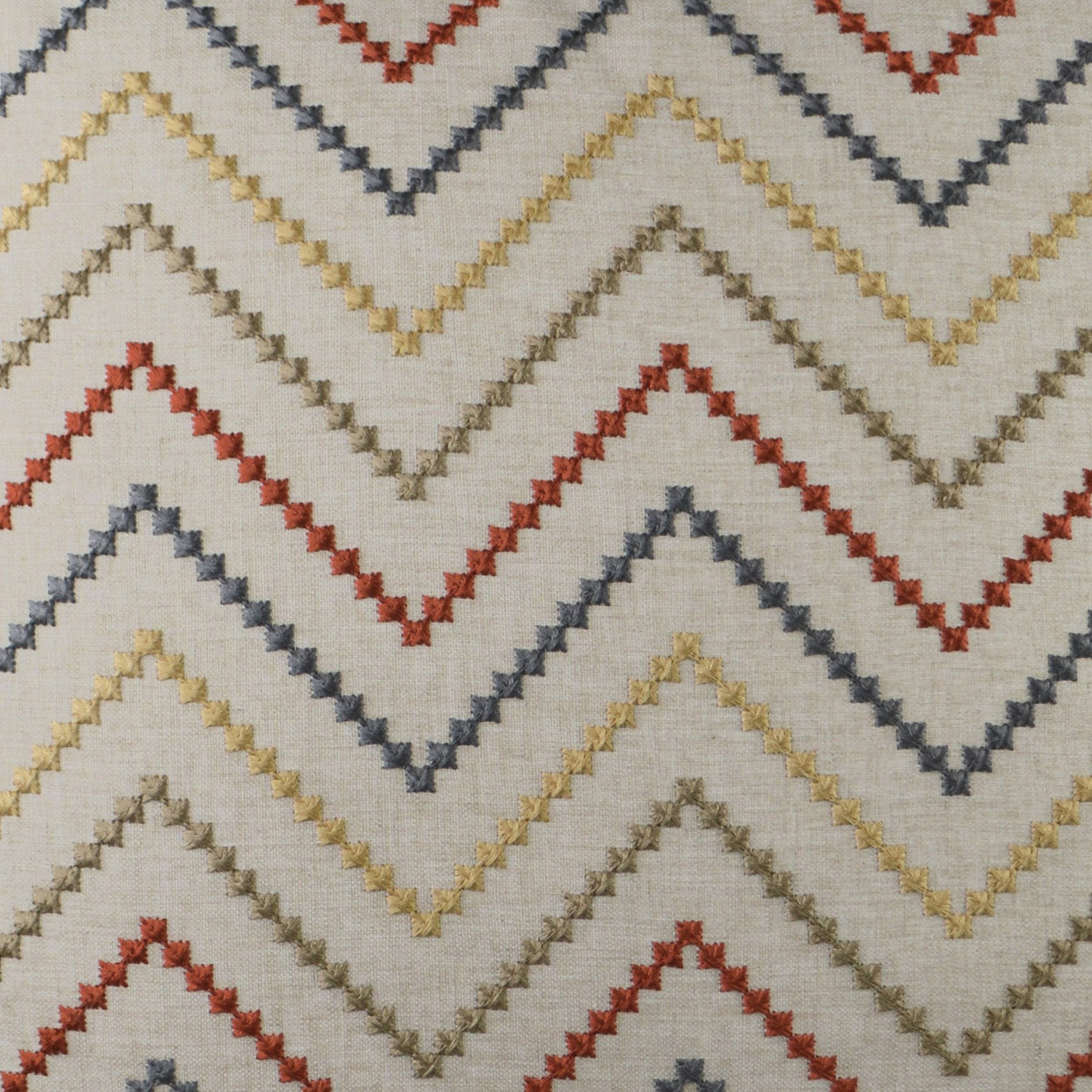 Chevron zigzag fabric pattern on light background with mustard, red, gray & navy chevrons.
