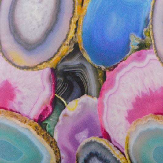 Close-up of vibrant agate geode slices with pink, purple, blue and teal bands and gold edges.