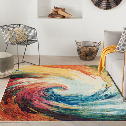 Living room with a swirled multicolor rug, gray metal chair, beige pouf, wicker basket, gray sofa and yellow throw.