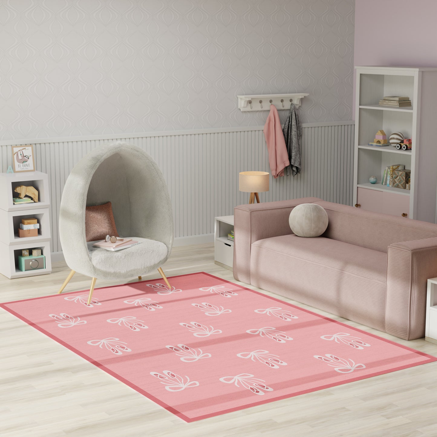 Pastel pink living room with a round gray pod chair, soft pink sofa, and a pink floral area rug.