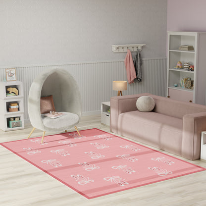 Pastel pink living room with a round gray pod chair, soft pink sofa, and a pink floral area rug.
