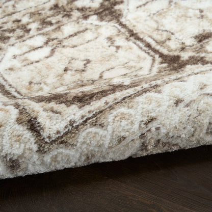 Cream and beige textured rug with brown pattern and plush pile, edge visible on dark wood floor.