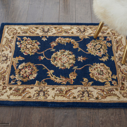 Persian-style area rug with deep blue field, cream-gold floral medallions, and ivory border on wooden floor.