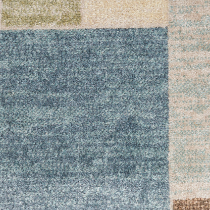 Patchwork shag rug in blue-gray, olive green, beige and tan blocks with a soft textured pile.