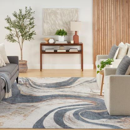 Living room with a blue-beige swirl rug, wooden console table, potted plant, lamp, and neutral sofas.