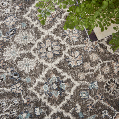 Taupe floral area rug with ivory and pale blue medallions, shaggy textured pile.