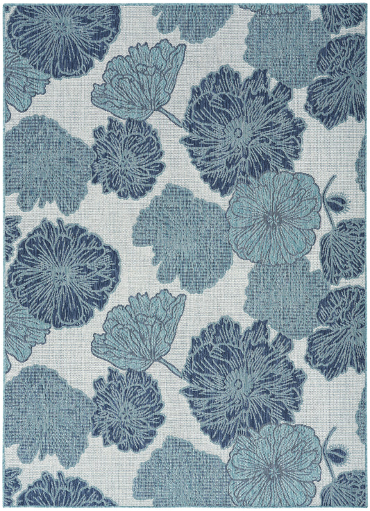 Blue floral print fabric with large hydrangea-like blossoms in navy and teal on a light linen-textured beige background.