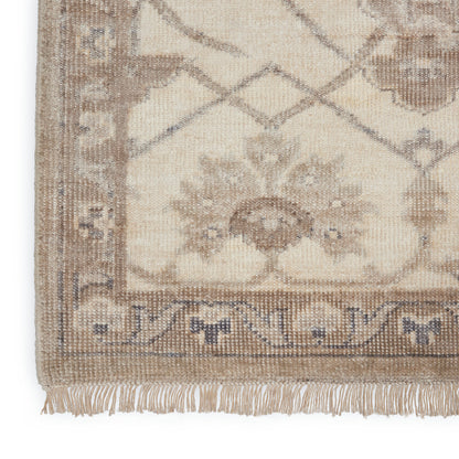 Beige oriental rug with taupe border, floral medallion center and fringed bottom edge.