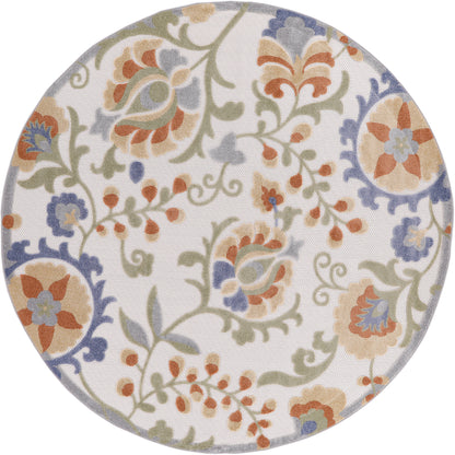 Round outdoor rug with a pastel floral scroll pattern in orange, blue, green and beige (5' diameter).