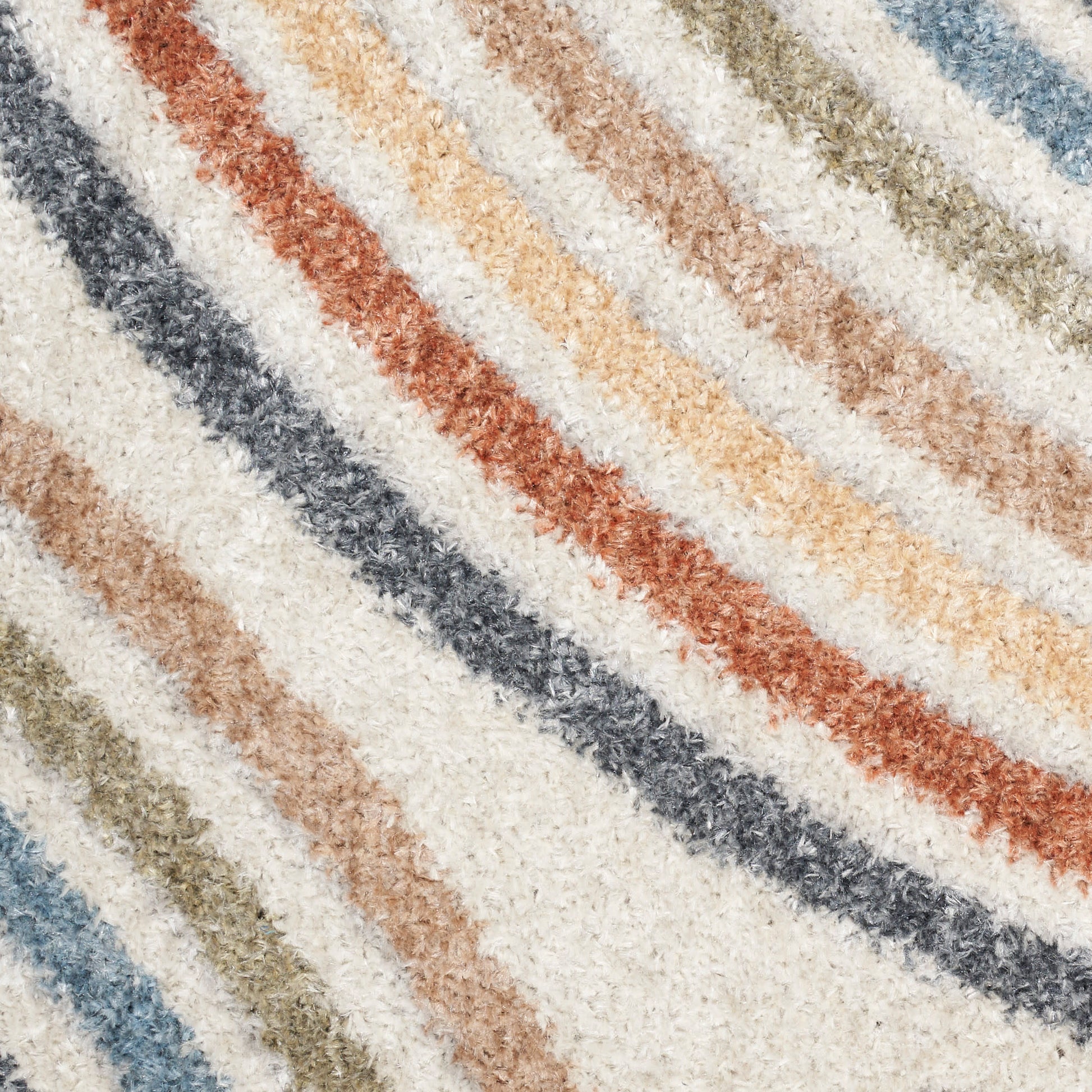 Diagonal striped shag rug with cream base and pastel stripes in rust, blue-gray, sage, tan, and beige.