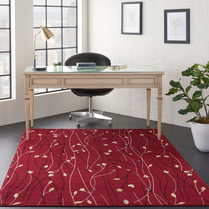 Beige wood desk with glass top and carved legs, black rolling chair, gold lamp, red vine-pattern rug, white brick wall.
