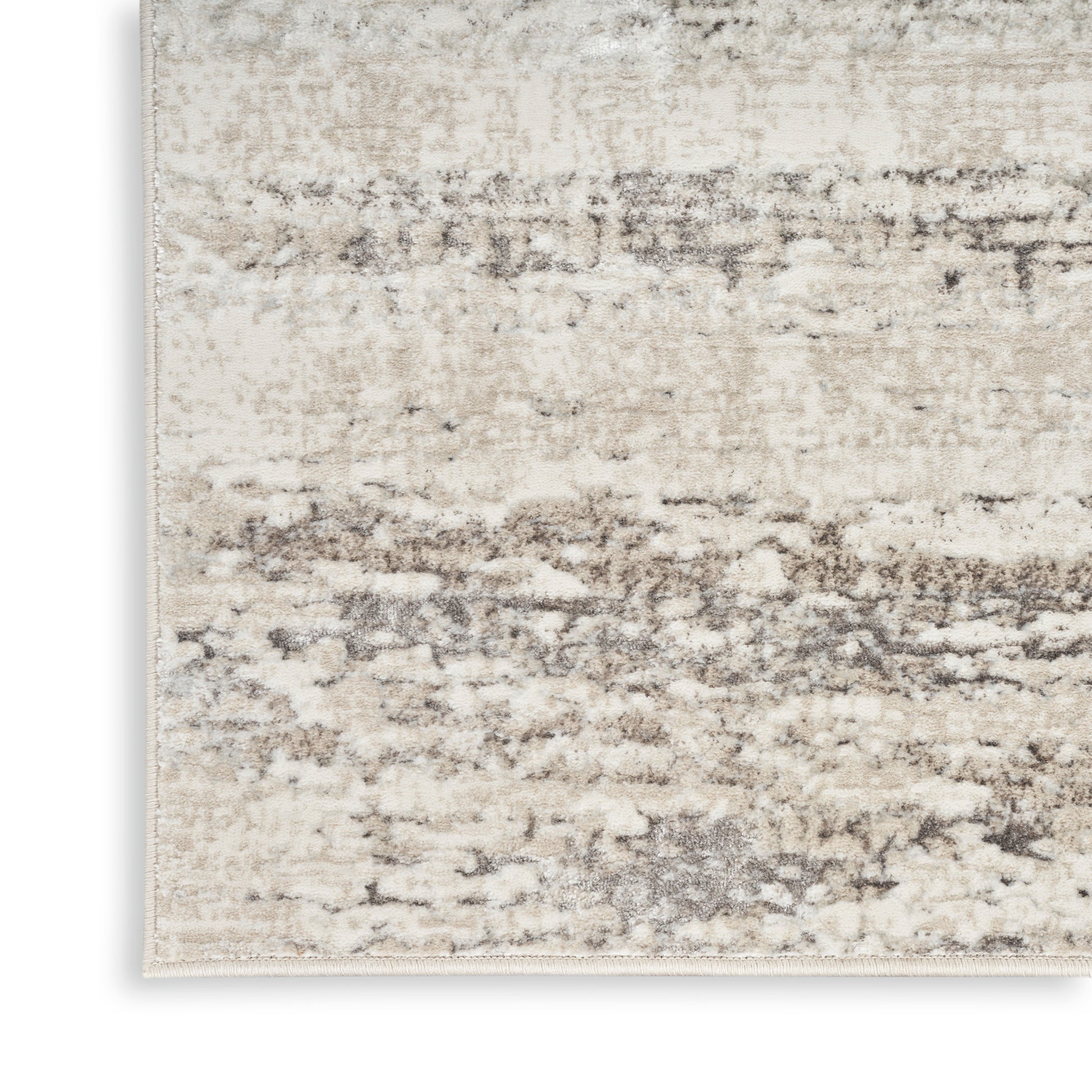 Neutral beige distressed area rug with taupe-gray abstract pattern; soft, textured fibers.