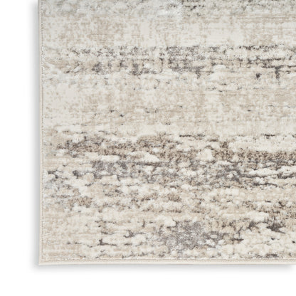 Neutral beige distressed area rug with taupe-gray abstract pattern; soft, textured fibers.