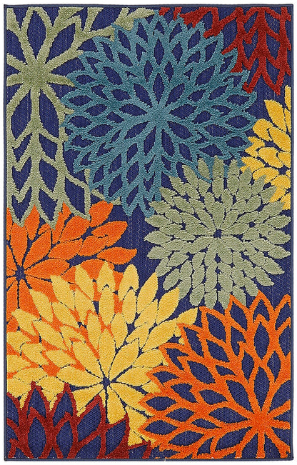 Woven rug with bold overlapping daisy-like flowers in blue, yellow, orange, and green on a dark navy background.