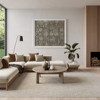 Neutral-toned living room featuring an 8' x 10' rug under a curved beige sectional, round wooden coffee table, abstract wall art, and a plant.