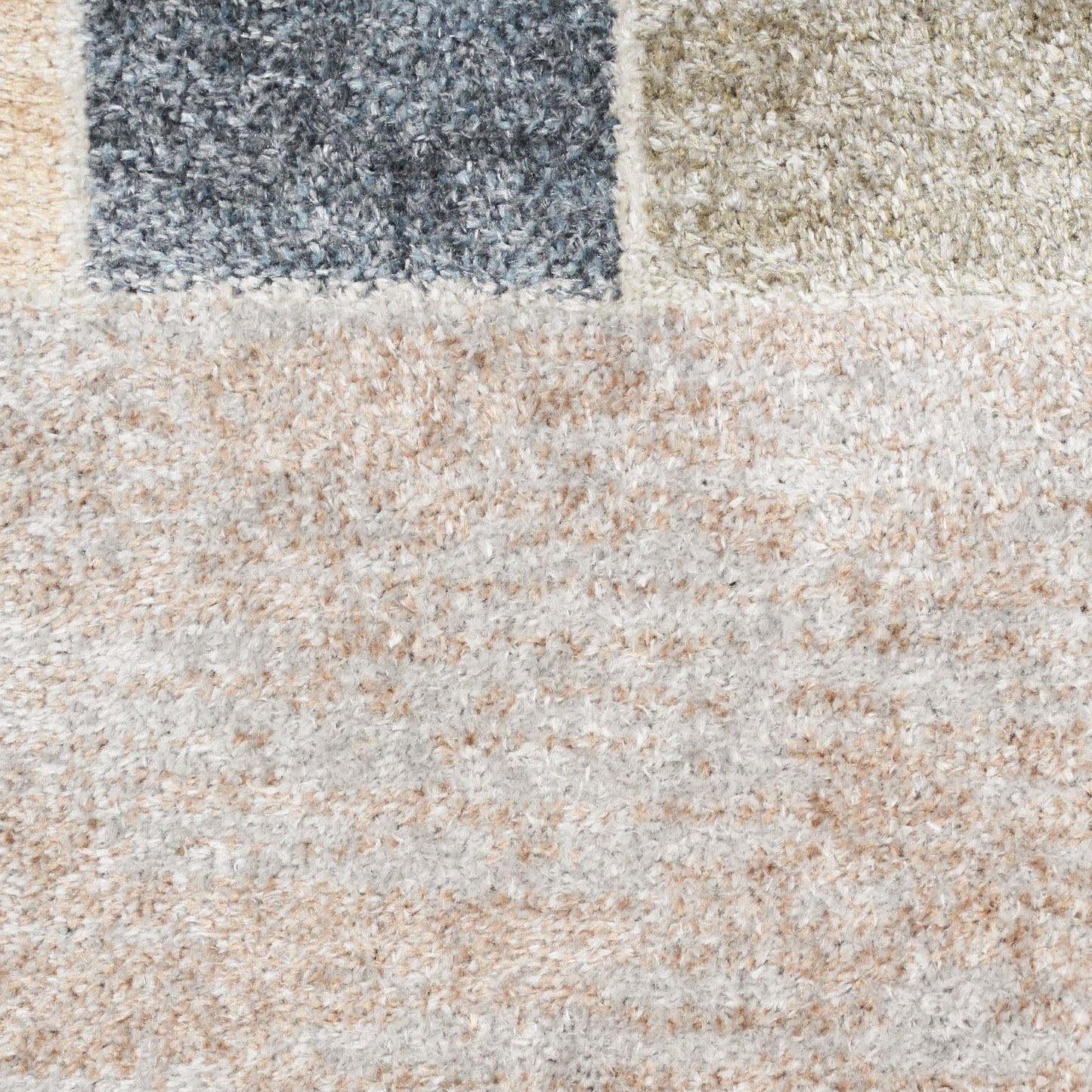 Beige shag rug with dark blue and olive patch blocks; soft textured pile, geometric area rug for living spaces.