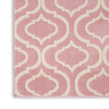 Pink rug with cream trellis motif, textured fabric, finished edge, close-up view.