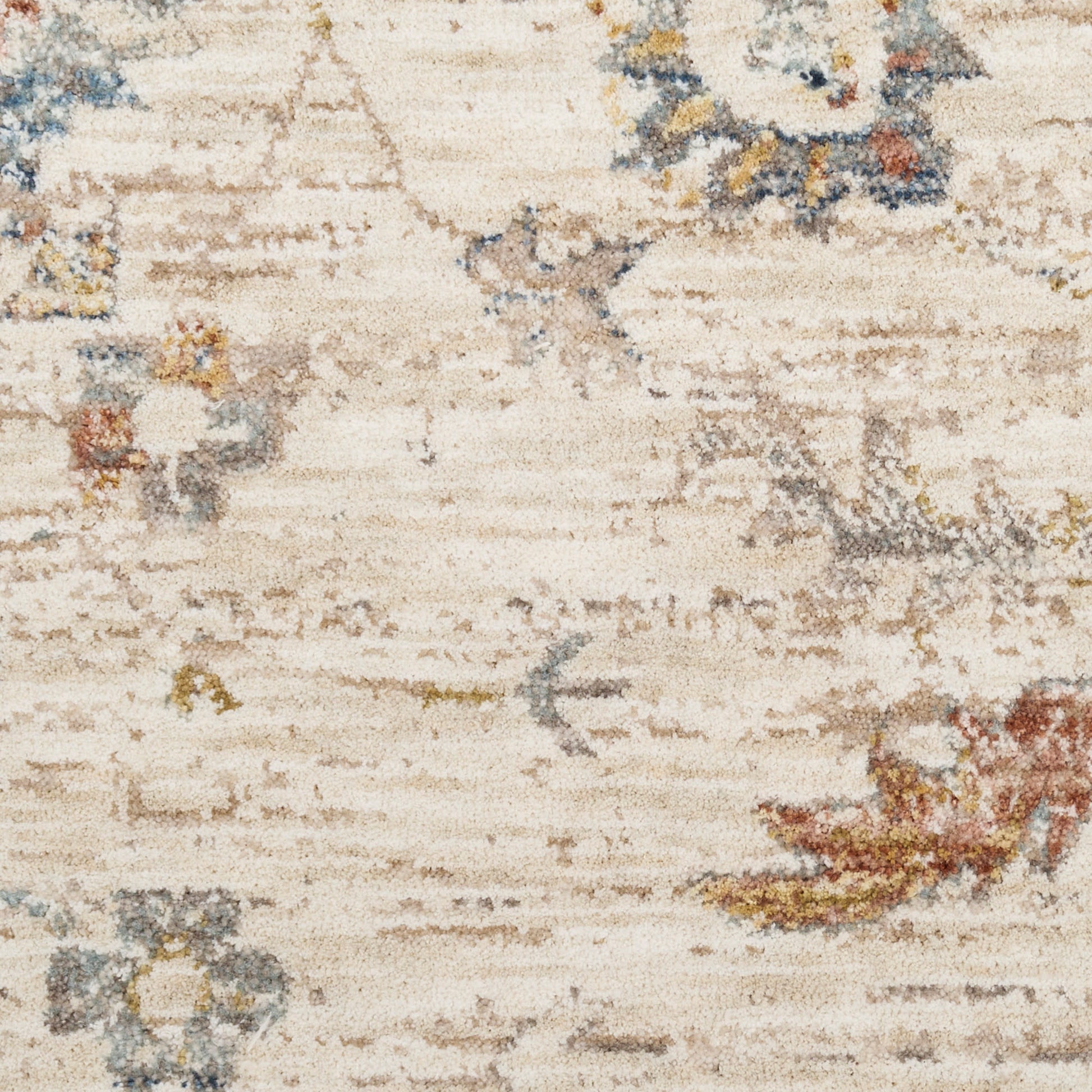 Cream distressed area rug with faded blue, gray, and rust floral motifs.