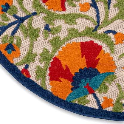 Round tufted rug with vibrant floral pattern, blue border, cream base, green vines, orange/red flowers and teal accents.