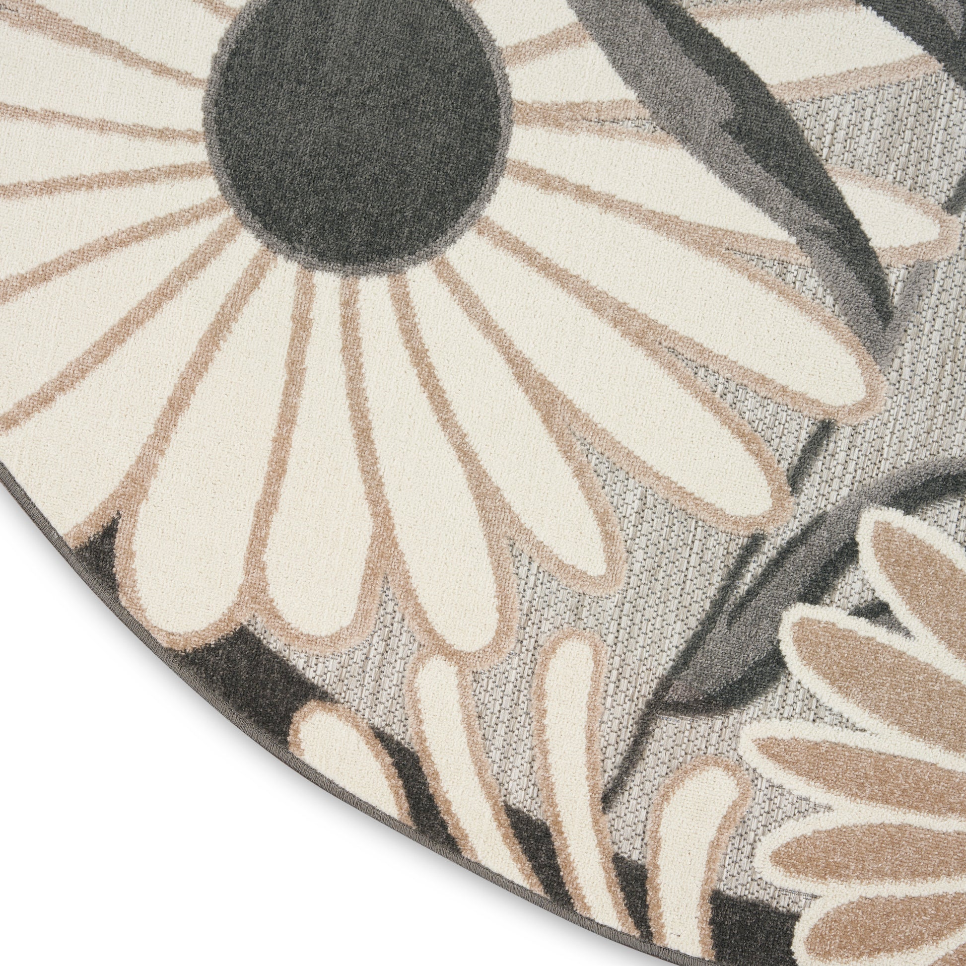 Round rug with oversized cream daisies and charcoal centers on a gray textured background.
