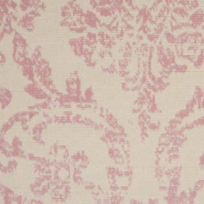 Cream-beige area rug with pink damask floral pattern and soft textile texture.