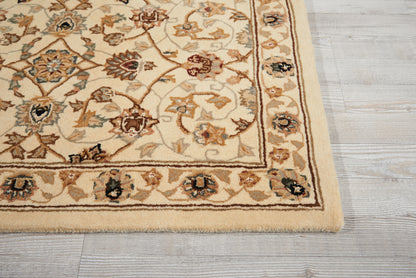 Beige oriental rug corner with floral medallions in brown, blue, and rust; decorative borders on light wood floor.
