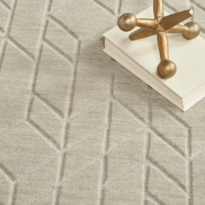 Beige geometric rug with raised diamond pattern; white book stack topped by a gold decorative cross.