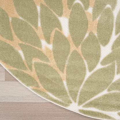 Round rug with sage green leaf pattern on beige backdrop; soft textured surface on light wood floor.