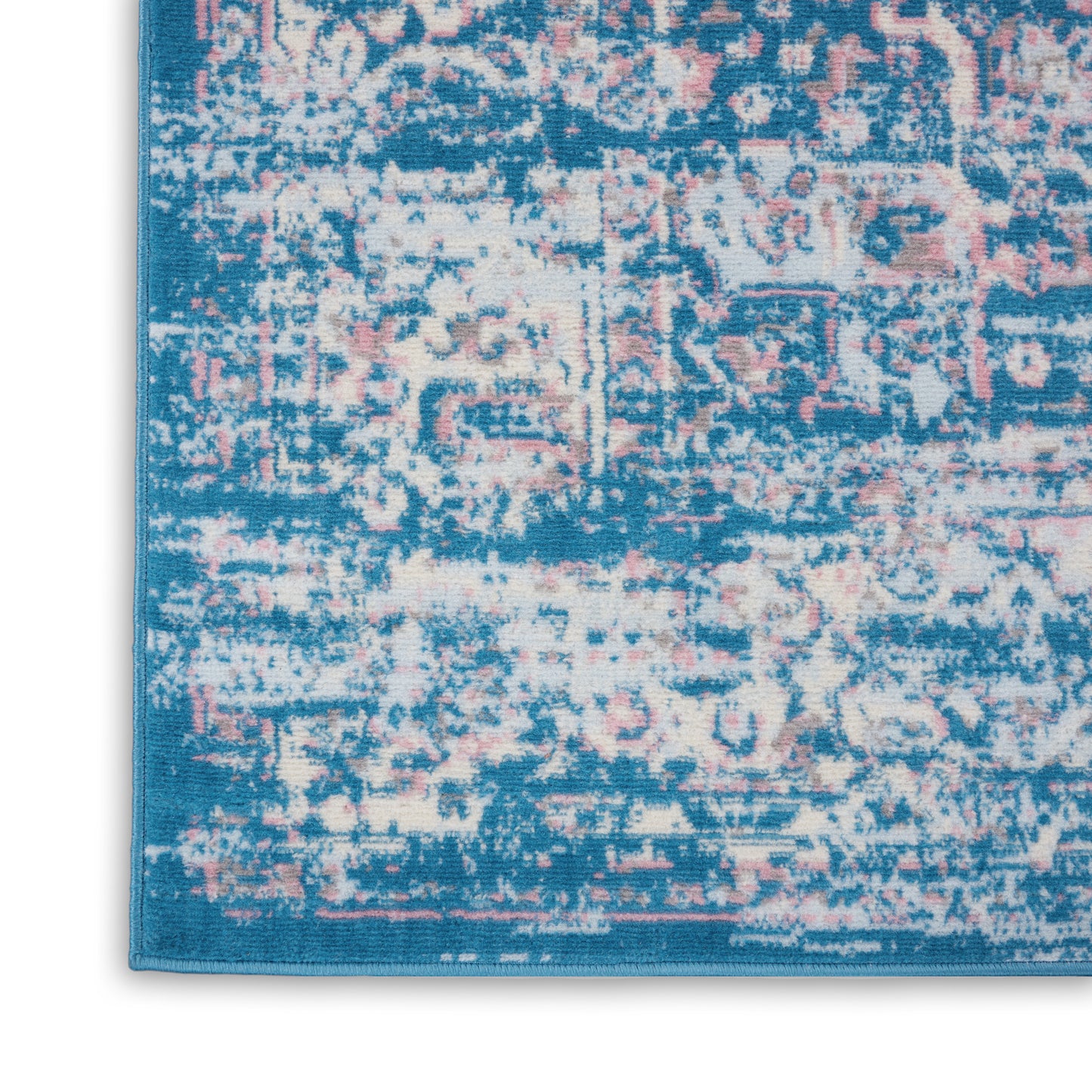 Distressed blue area rug with pink and cream motifs; turquoise border in a vintage oriental pattern.