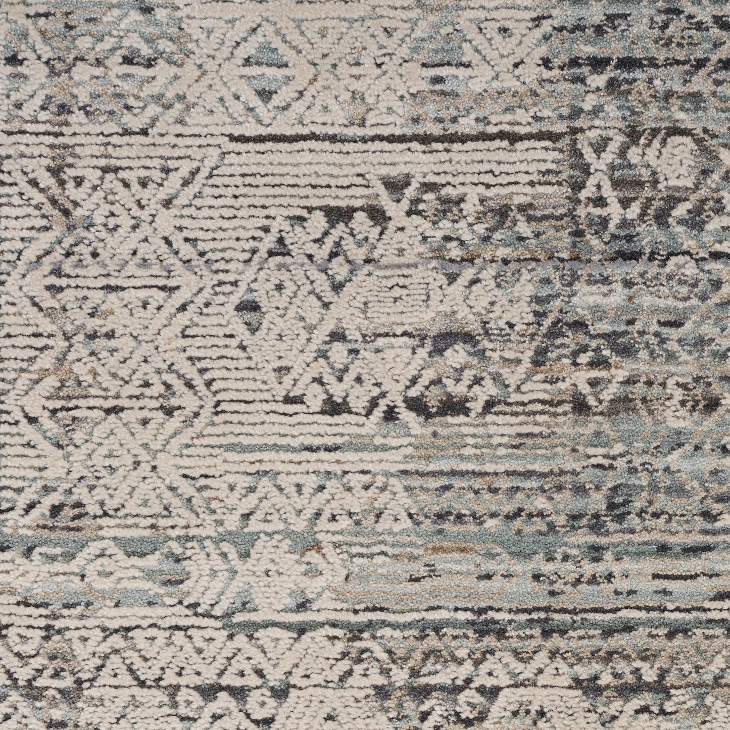 Distressed kilim-style rug with teal, beige, ivory and gray geometric patterns; woven texture, boho living-room decor.