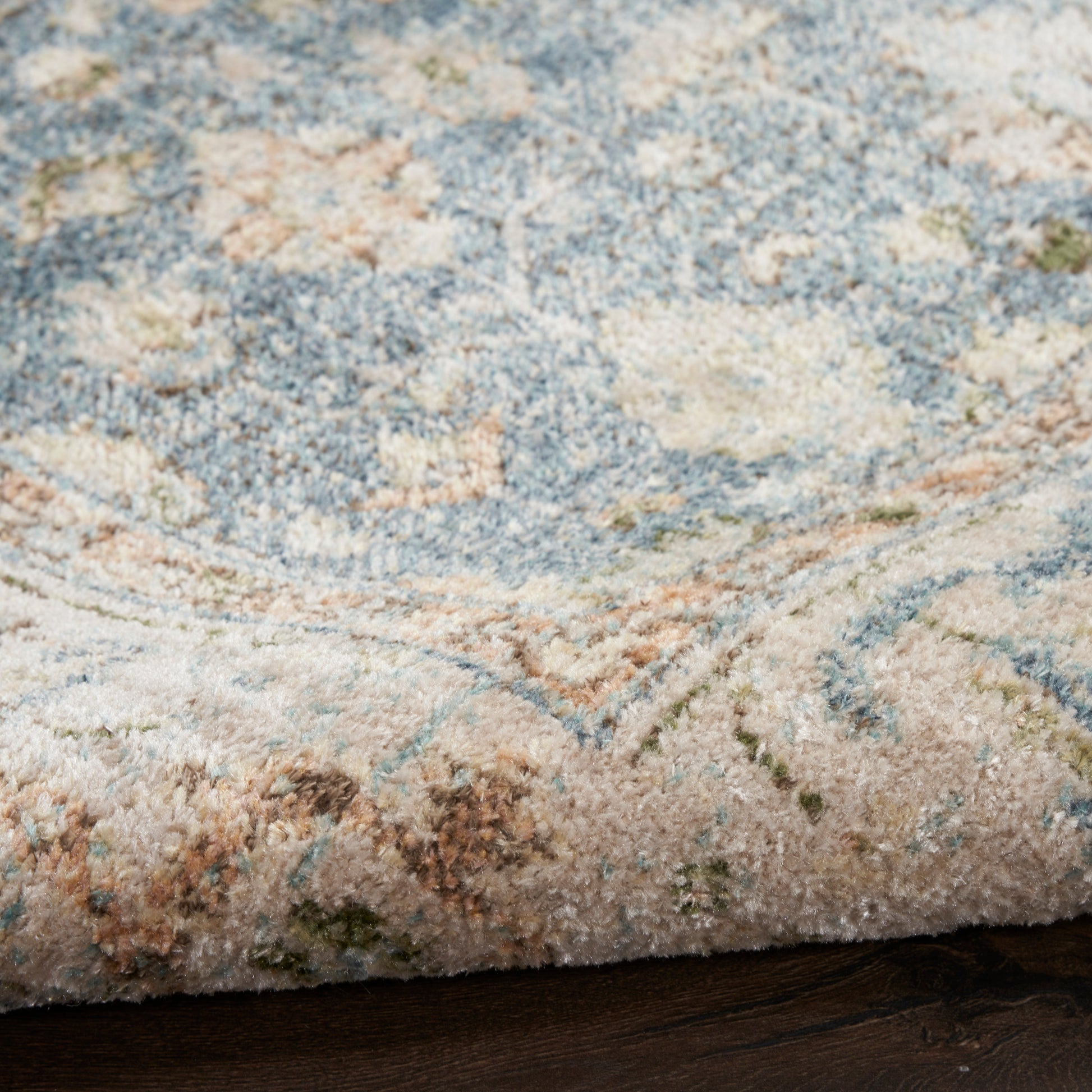 Plush blue and cream area rug with peach and sage accents in a traditional floral damask pattern.