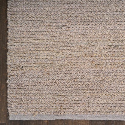 Beige textured loop-pile rug with natural fibers on dark wood floor.