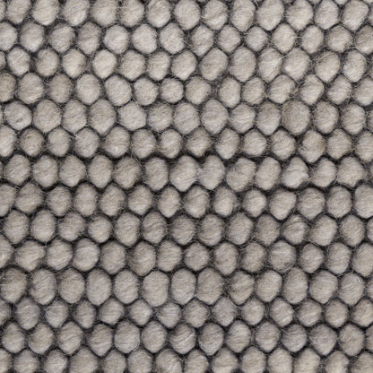 Gray rug with a pebble-textured surface and tiny rounded bumps; 9' x 12'.
