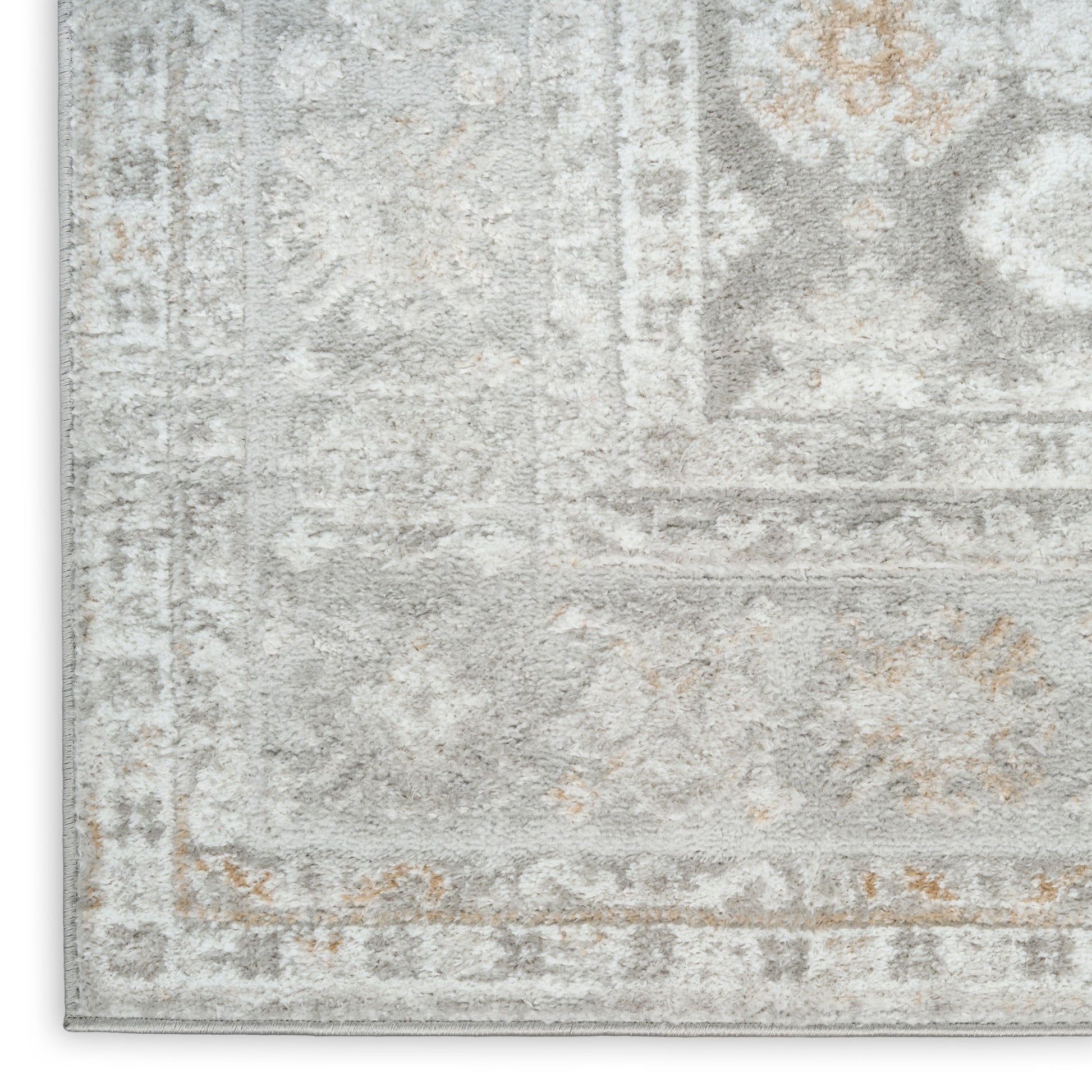 Close-up of a gray and ivory distressed rug with subtle beige accents; rectangular with an ornate border.