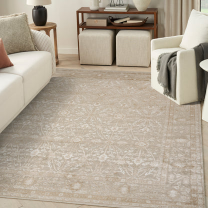 Cream area rug with muted ivory floral pattern and subtle border in a neutral living room.