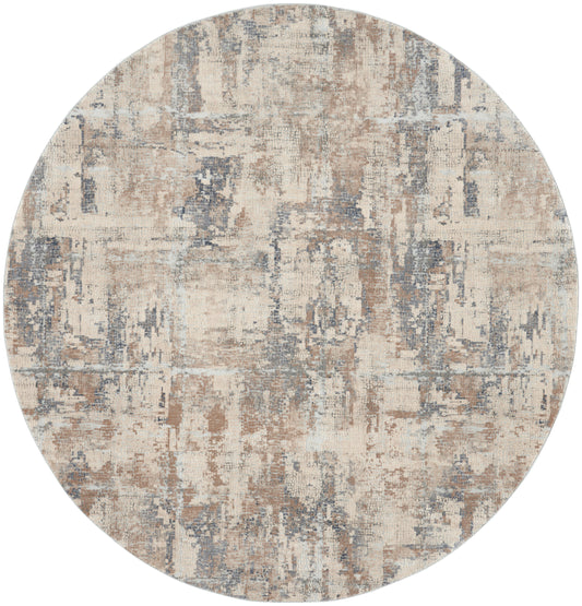 Round abstract area rug in beige, tan, gray and blue tones with a distressed pattern.
