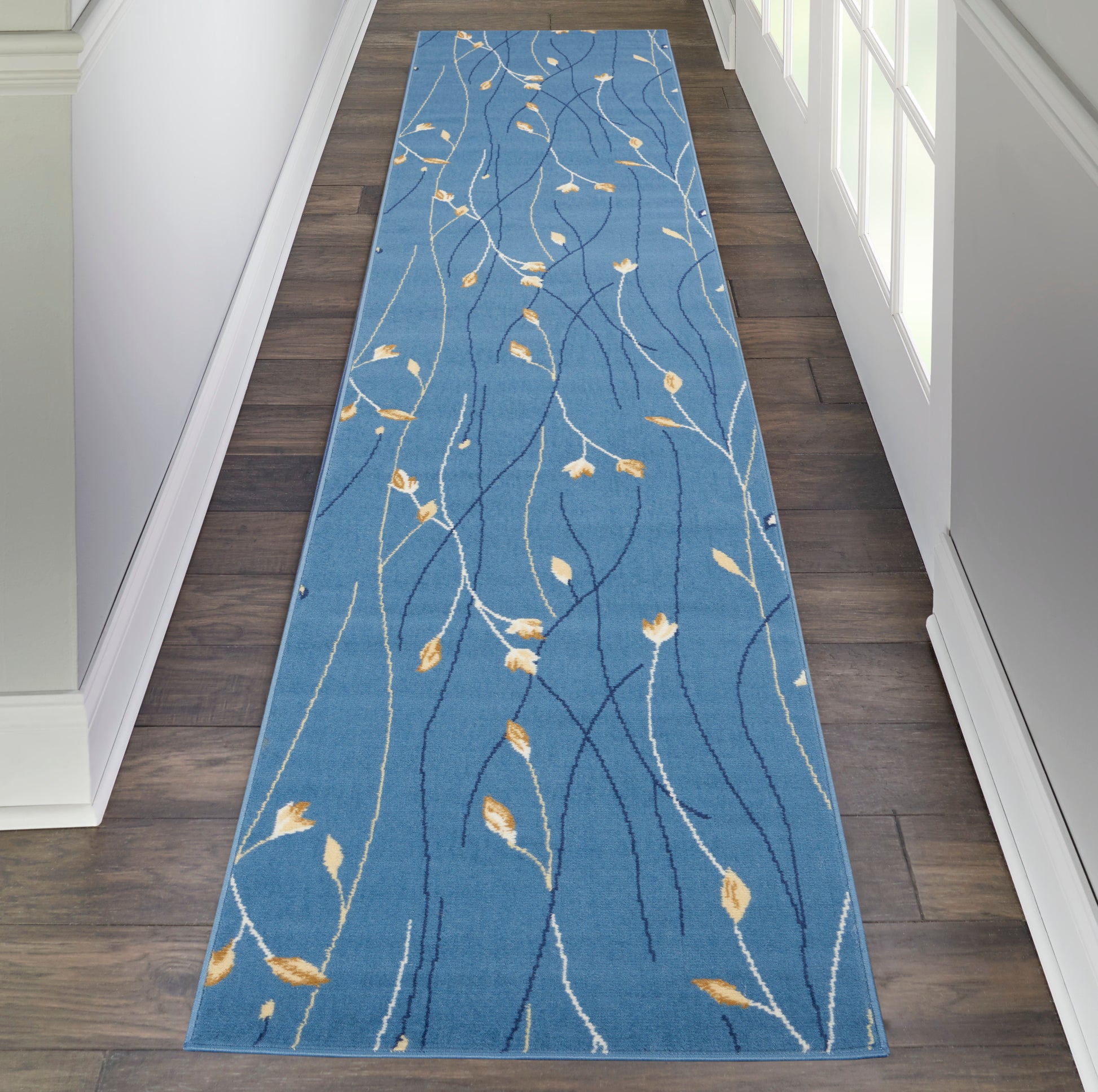 Blue hallway runner rug with white & pale yellow leaf-vine pattern; rectangular, soft texture for entryway or corridor.