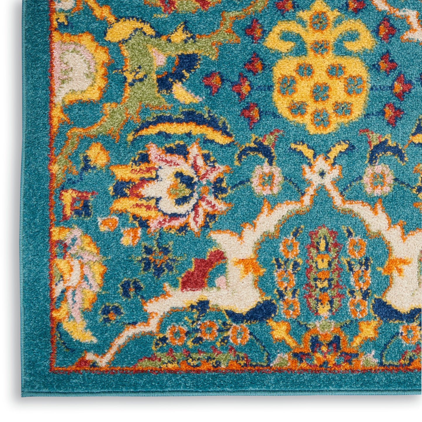 Close-up of teal tufted rug with vibrant yellow and orange floral medallions and ivory scrollwork.