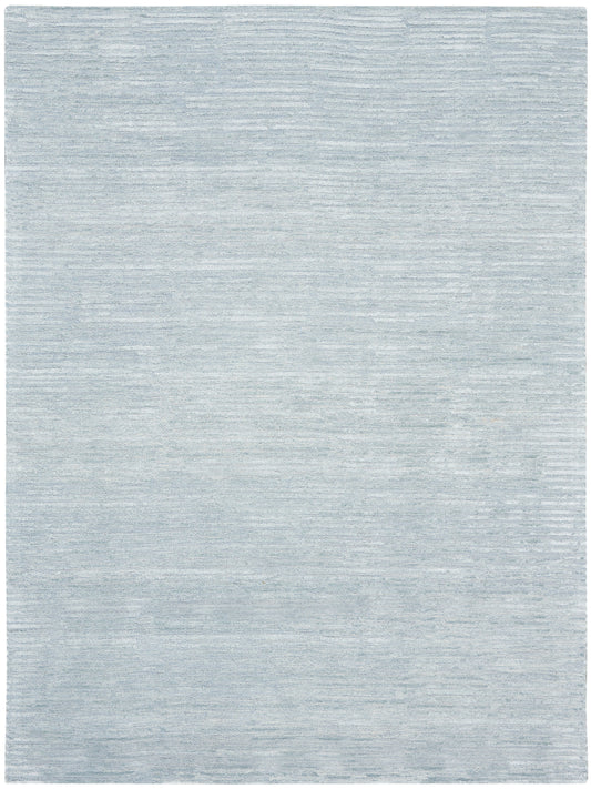 Light blue-gray rug with soft, subtle tonal variations and a flat-weave texture; rectangular, modern living room decor.