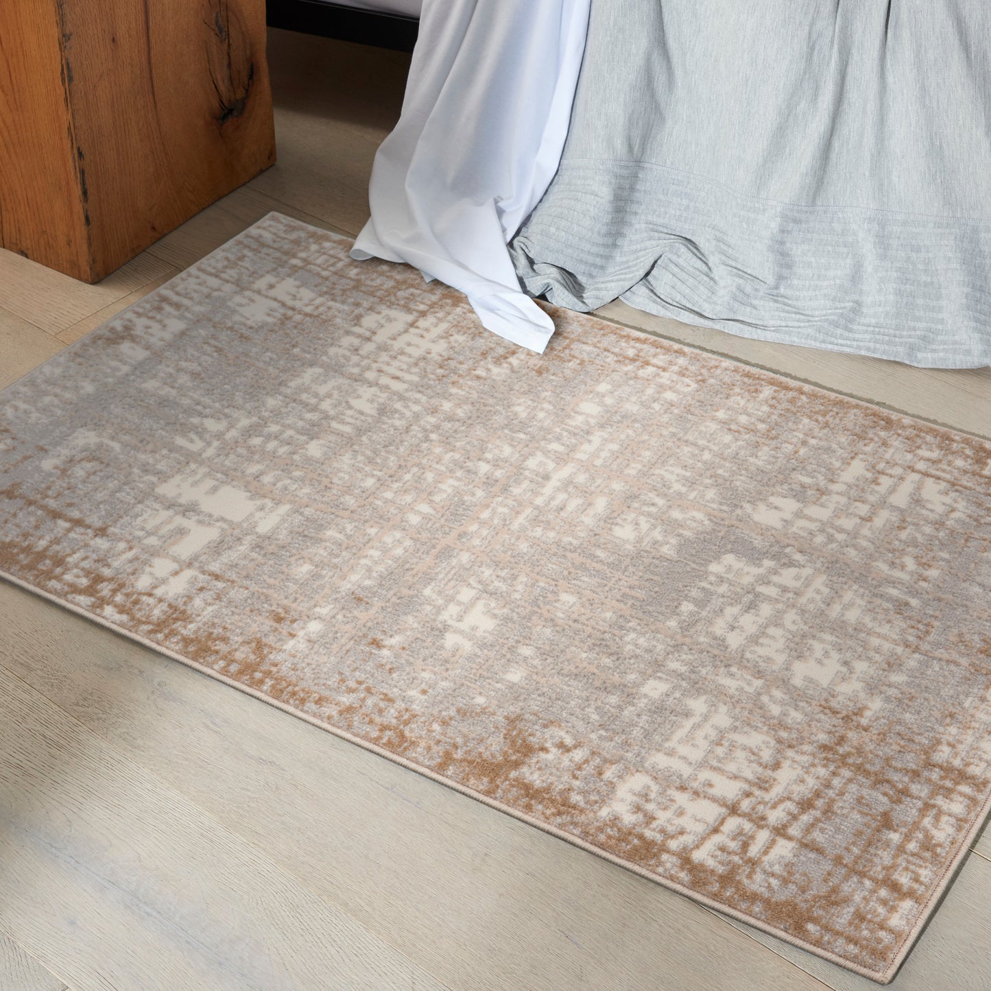 Rectangular area rug in beige, taupe and light gray with an abstract pattern; soft low-pile.