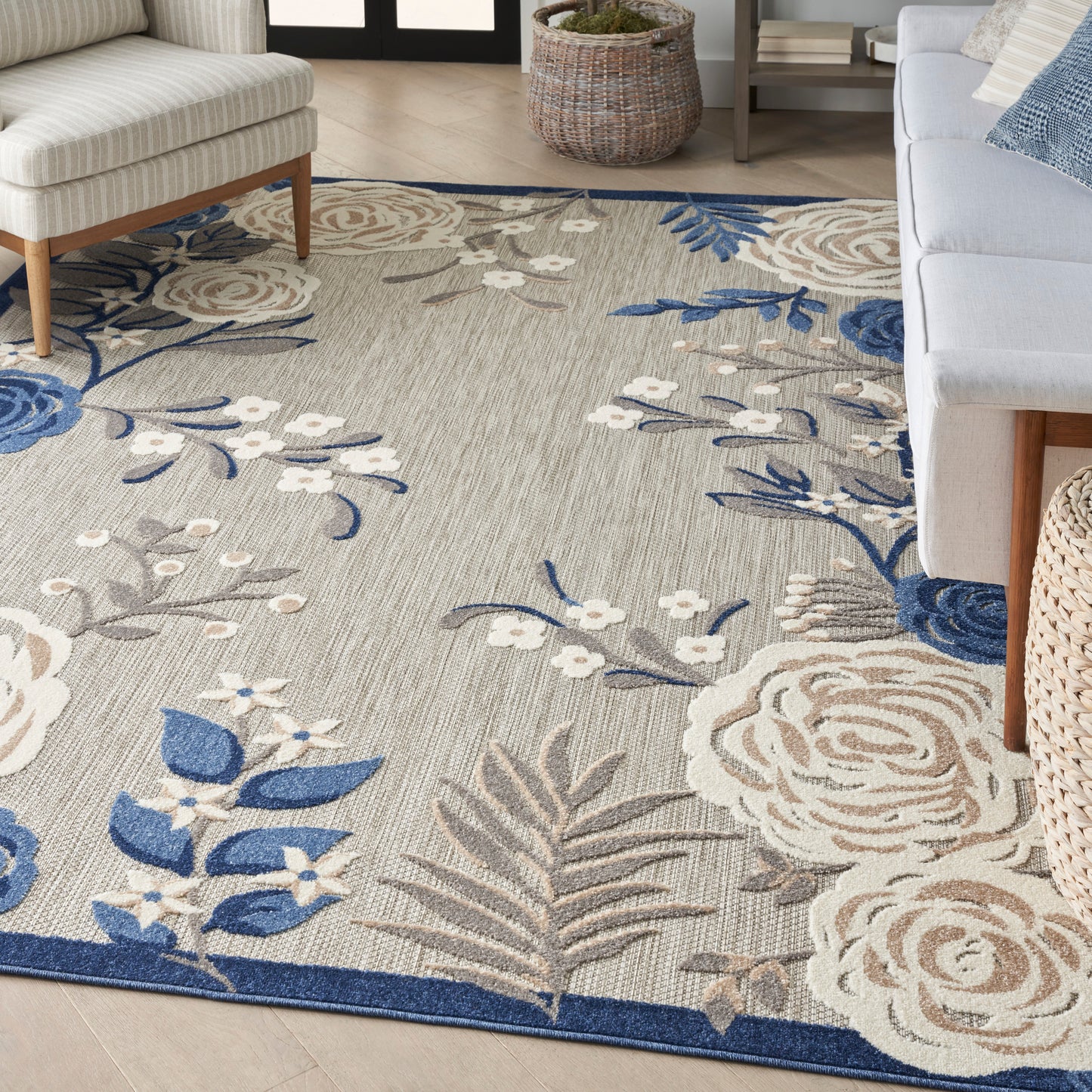 Beige floral area rug with blue and white blooms, in a modern living room with light upholstery.
