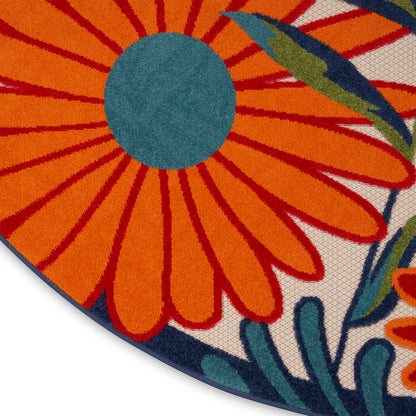 Round floral rug with bright orange petals, teal center, navy border, woven texture, vivid spring decor.