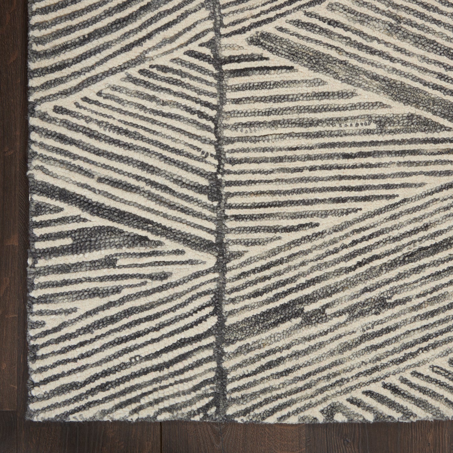 Rectangular ivory and charcoal rug with bold linear geometric pattern; plush textured pile on dark wood floor